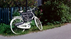 white-city-bike-parked-beside-white-wooden-fence-scaled